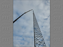 A crane & climbing crew setting the last piece of a new 340' tower.